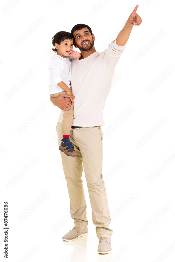 young indian father and son pointing at empty space young indian father and son pointing at empty space