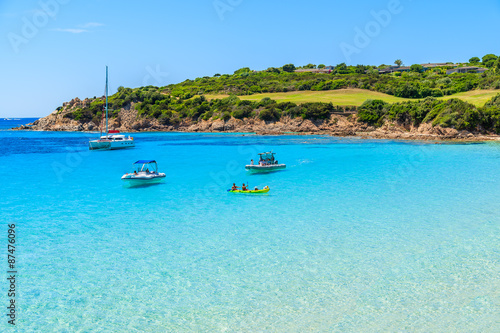 Boats and kayak on turquoise sea water of Grande Sperone bay, Corsica island, France.