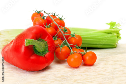 the branch of cherry tomatoes, red pepper and celery stalks on a napkin