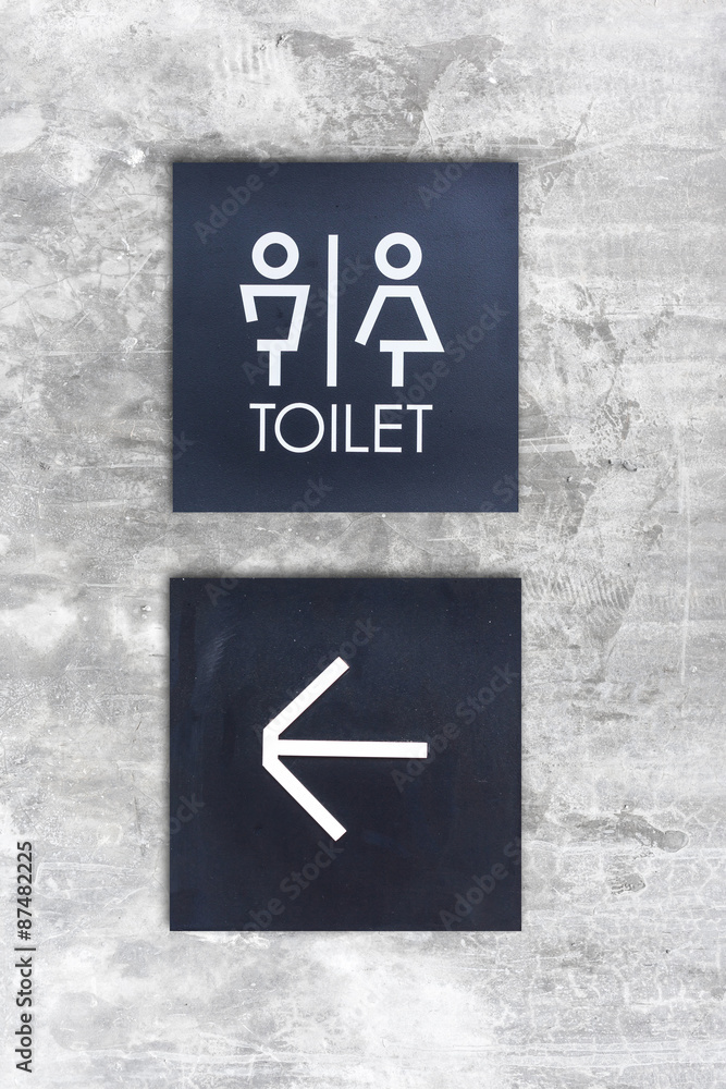 Fototapeta premium Unisex restroom or Toilet and arrow sign on concrete wall style