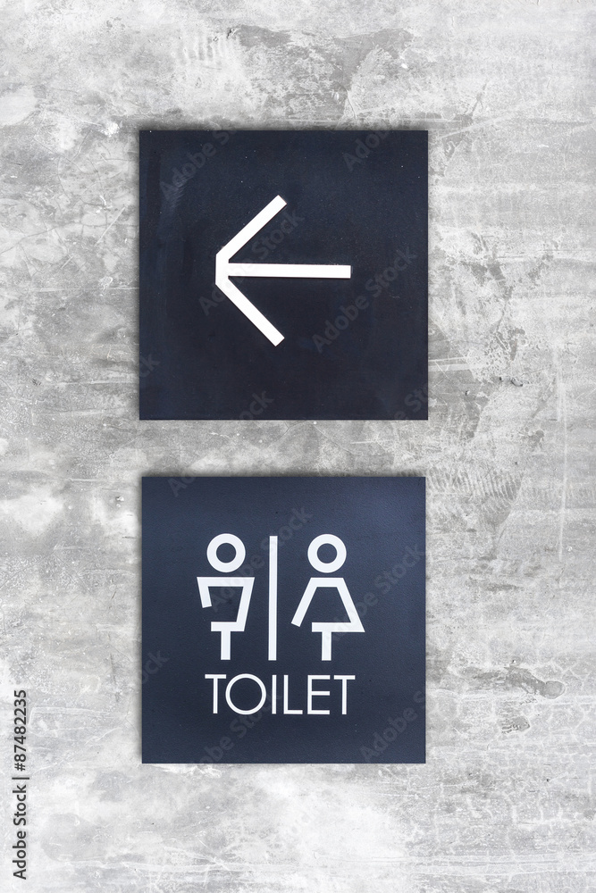 Unisex restroom or Toilet and arrow sign on concrete wall style Unisex restroom or Toilet and arrow sign on concrete wall style