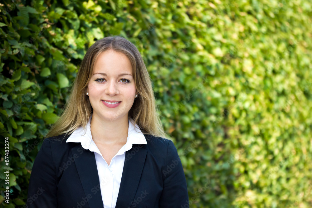 junge blonde Geschäftsfrau steht vor einem grünen Hintergrund junge blonde Geschäftsfrau steht vor einem grünen Hintergrund