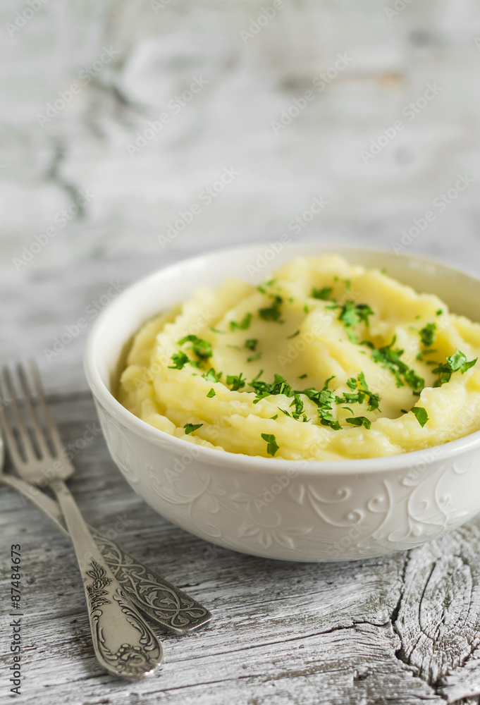 mashed potatoes in a white bowl on a light wooden background