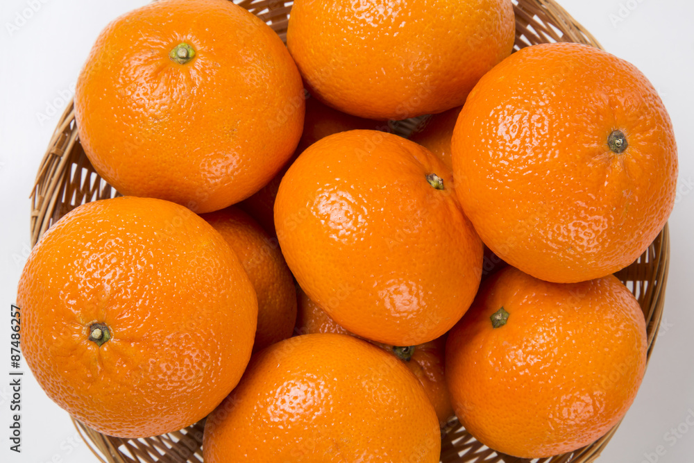 Some tangerines in a basket over a wooden surface Some tangerines in a basket over a wooden surface