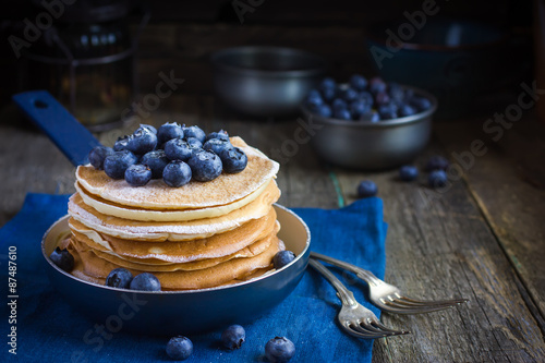pancakes with blueberry and powdered sugar in pan