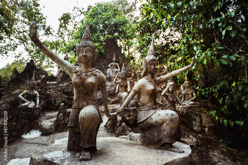 Row of old statues in secret buddhist garden