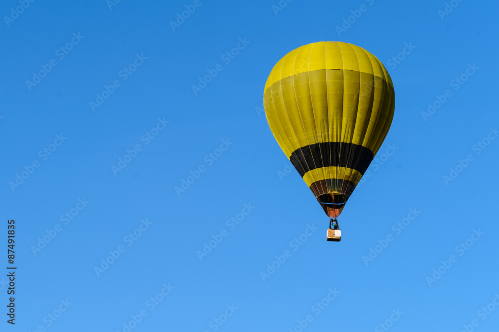 Naklejka premium yellow hot air balloon in blue sky