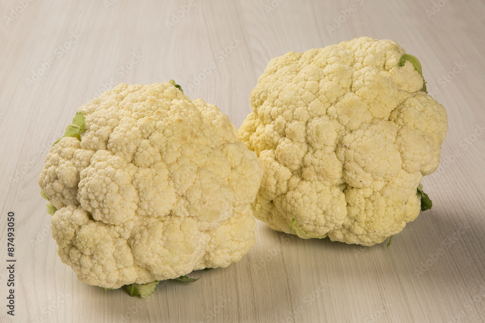 Some white cauliflowers over a wooden surface seen from above Some white cauliflowers over a wooden surface seen from above