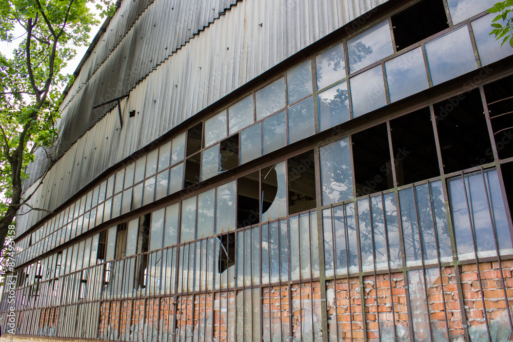 Obraz premium stara konstrukcja budynku przemysłowego / magazyn przemysłowy opuszczony i opuszczony z rozbitą szybą