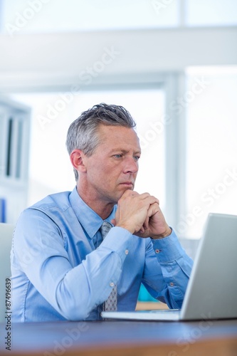 Concentrated businessman looking at laptop computer 