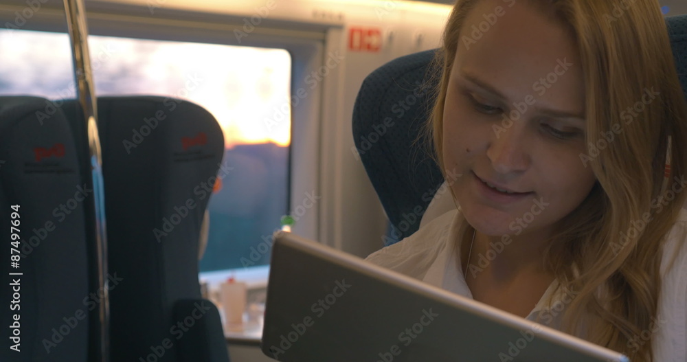 Woman communicating on touch pad during train ride Woman communicating on touch pad during train ride