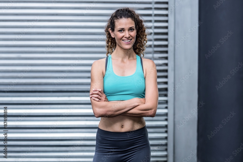 Smiling muscular woman with arms crossed