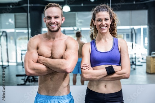 Smiling muscular couple looking at the camera