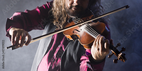 Cuadro en lienzo handsome man playing classical violin through blue smoke