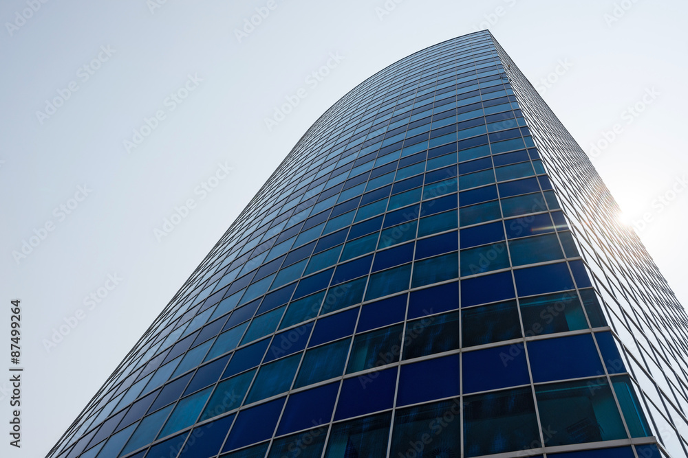 Blue glass modern business center with sun behind
