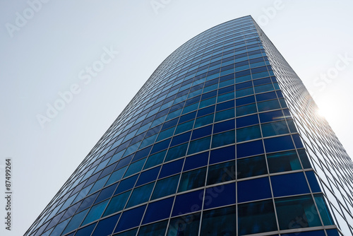 Blue glass modern business center with sun behind