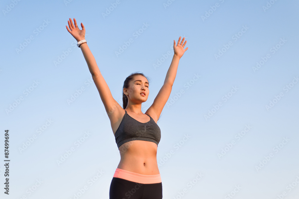 Asian woman raising arms to the sky. Asian woman raising arms to the sky.