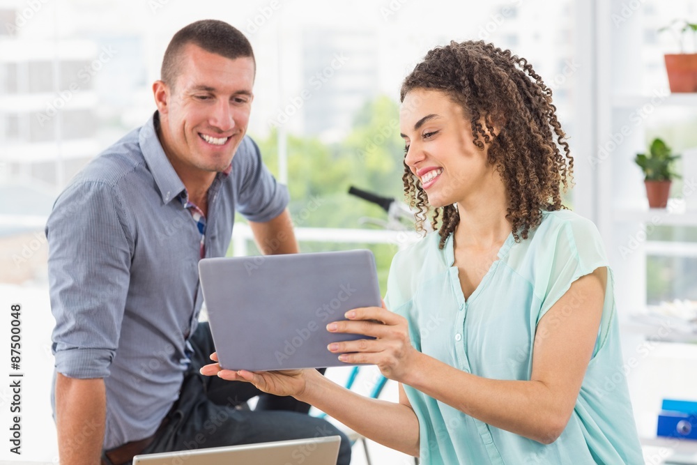 Businesswoman showing tablet to her colleague