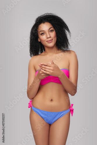 Smiling woman in swimsuit with cell phone