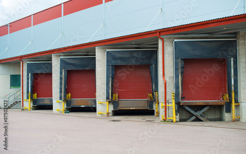 Warehouse with four red sliding gates.