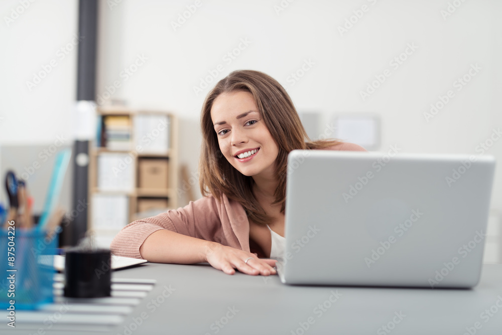 junge frau sitzt am schreibtisch und arbeitet am laptop junge frau sitzt am schreibtisch und arbeitet am laptop