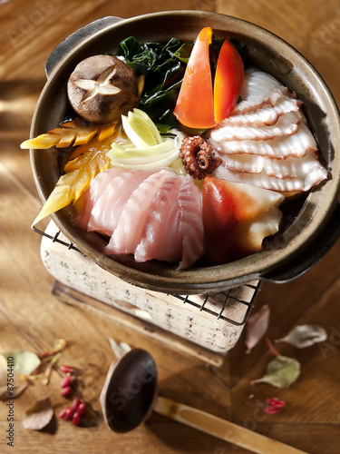 japanese Sukiyaki. sliced yellowtail, Red Snapper, Surf Clam, shiitake mushrooms and wakame seaweed boiled on fire photo