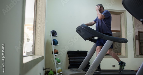 Timelapse of a senior man exercising on treadmill photo