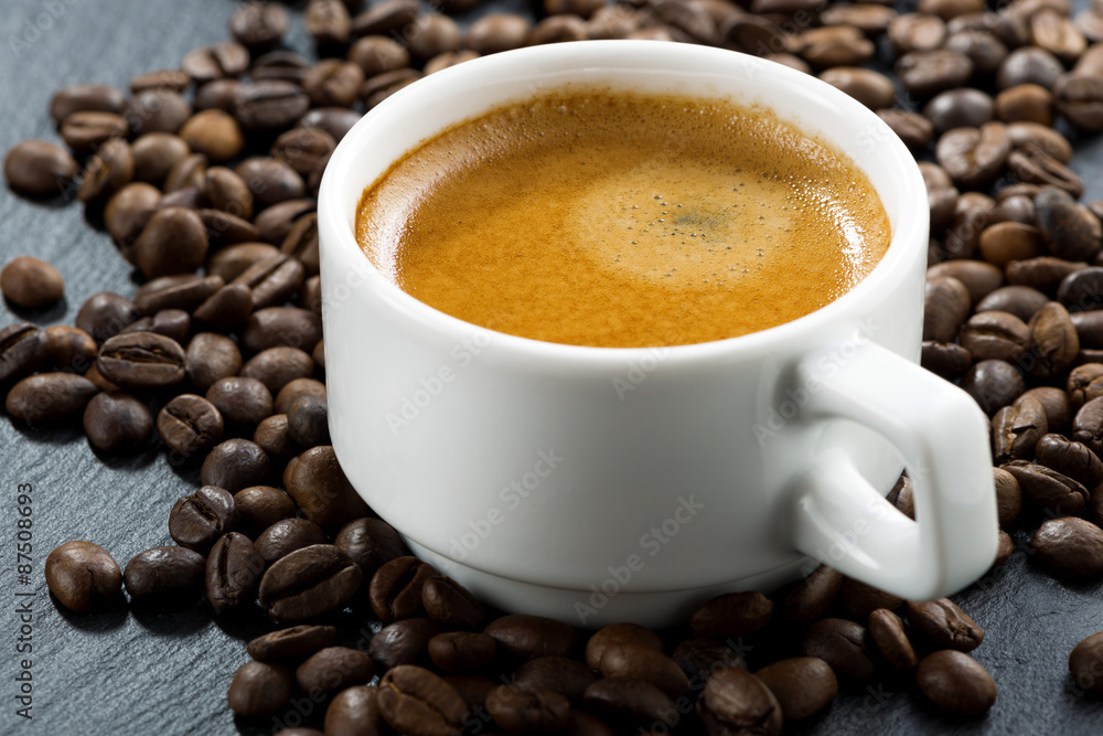 Fototapeta premium espresso on coffee beans background, close-up, selective focus