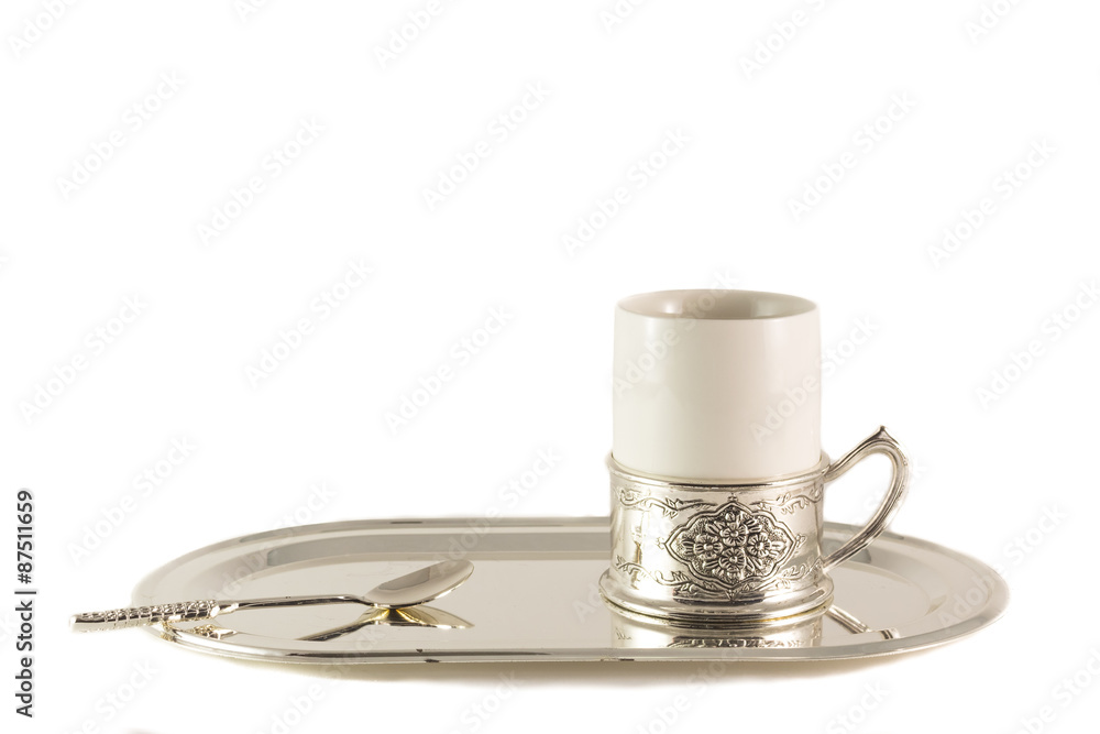 White porcelain coffee Cup with silver spoon on tray