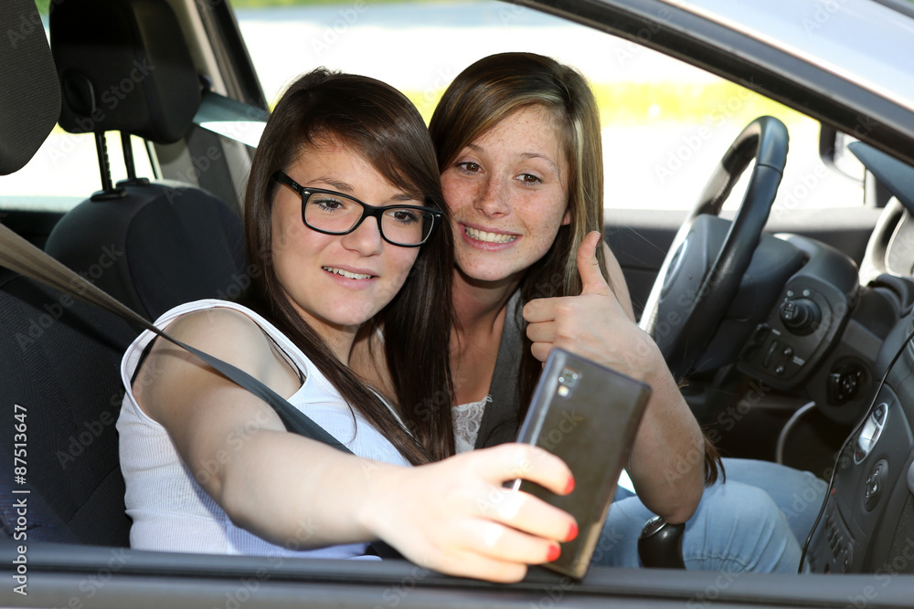 Deux copines se prenant en photo dans une voiture