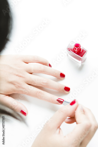 Frau lackiert ihre Fingern  gel mit rotem Nagellack