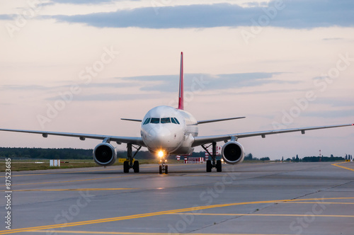Perspective view of jet airliner at taxiway. Evening scene with
