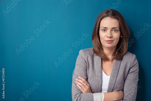 geschäftsfrau mit verschränkten armen vor blauem hintergrund © contrastwerkstatt