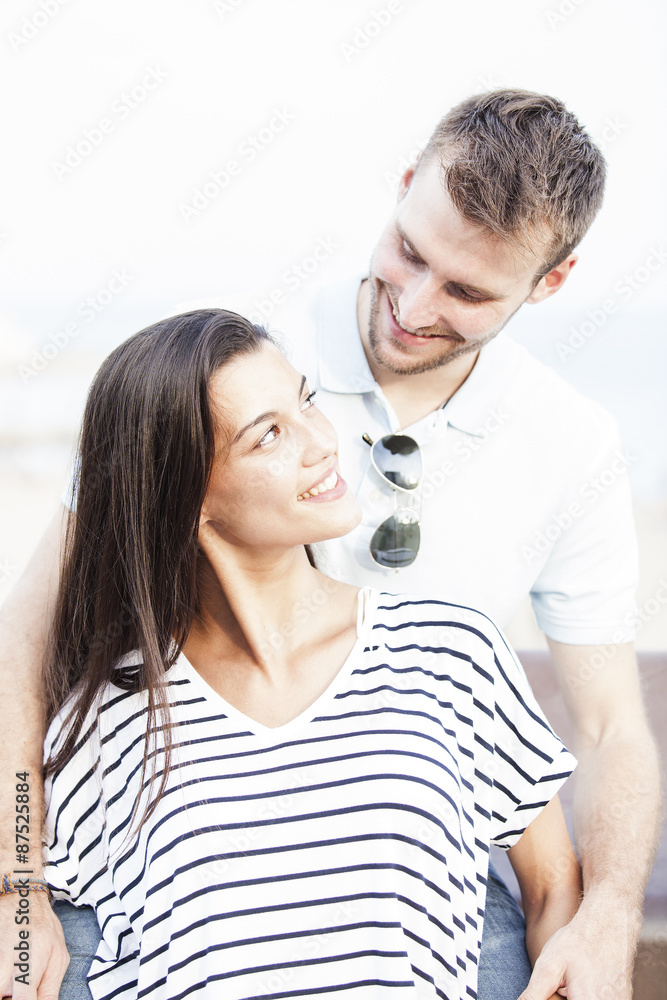 Funny couple laughing with a white perfect smile and looking each other outdoors with unfocused background. Love concept Funny couple laughing with a white perfect smile and looking each other outdoors with unfocused background. Love concept
