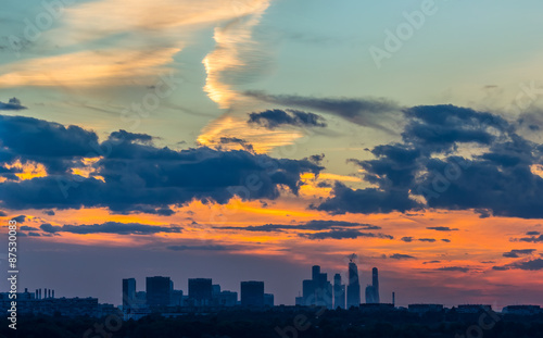 Beautiful orange sunset over the city with different clouds