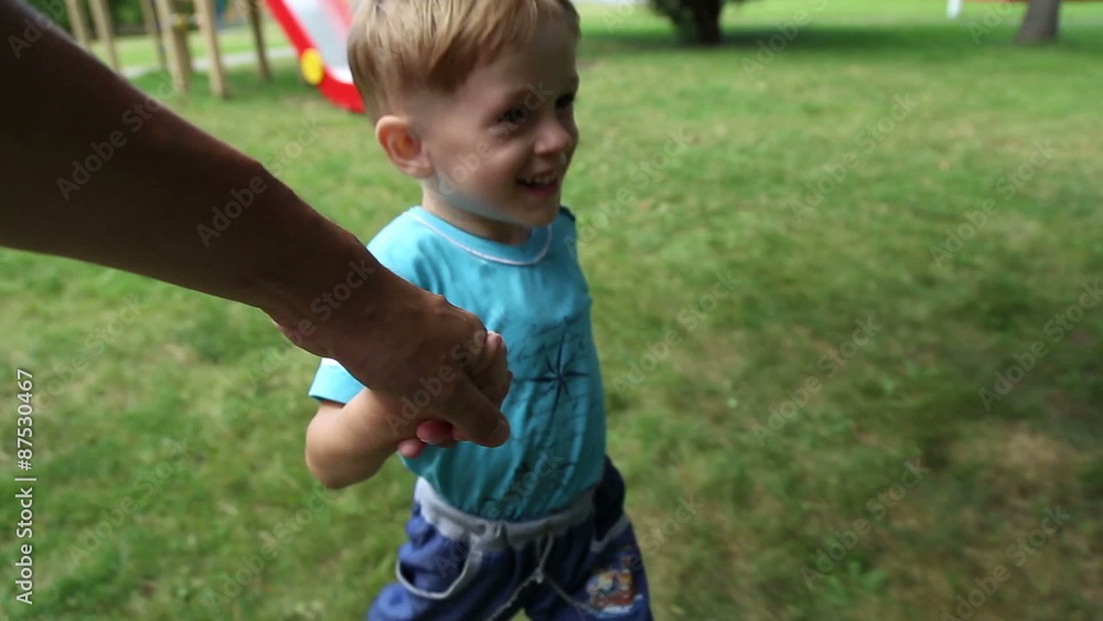 Boy runs, holding his father's hand, he laughs and fun
Boy runs, holding his father's hand, he laughs and fun