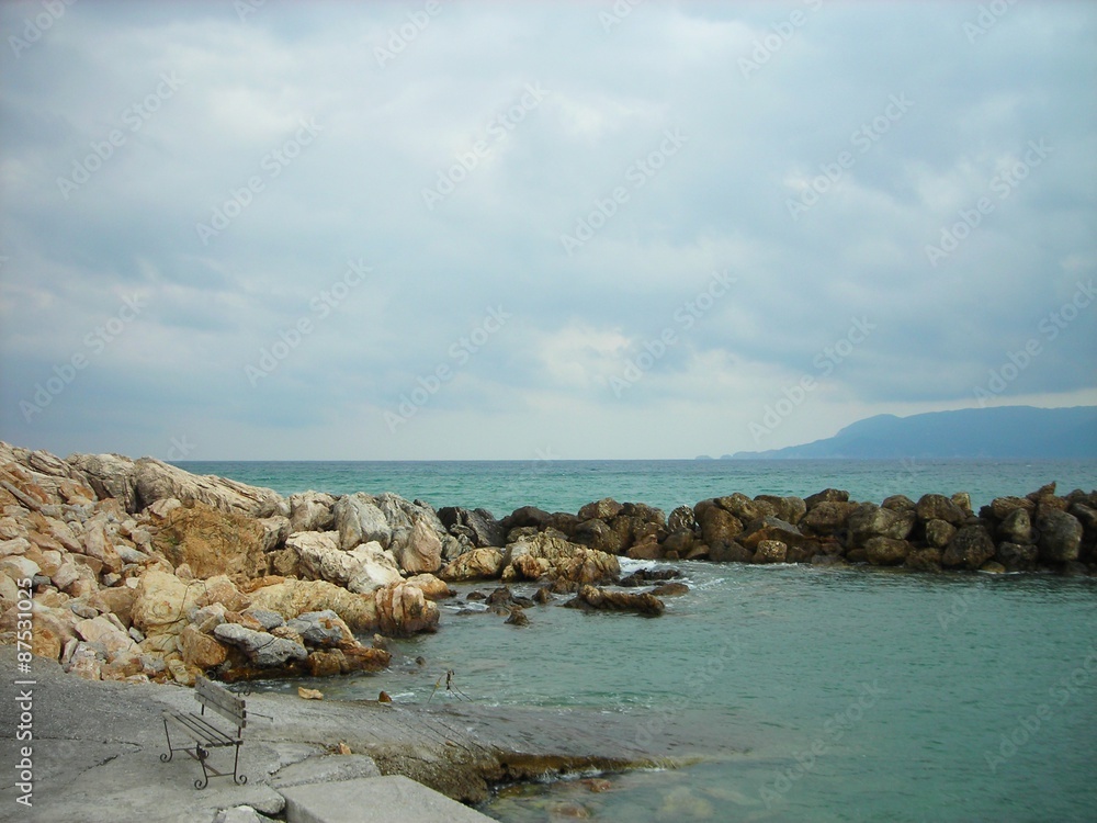 Coastal landscape on the Greek peninsula Pelion, with rocky beach and dramatic sky, just after rain, in early autumn.