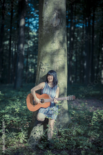 Inspired musician singer with guitar in forest, brussels