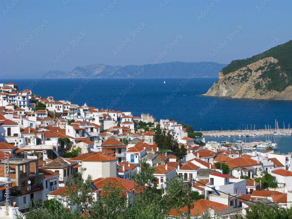Sunny Skopelos town on background of Aegean sea. Skopelos island, Northern Sporades, Greece.