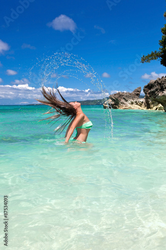 Woman in ocean waving and splashing water