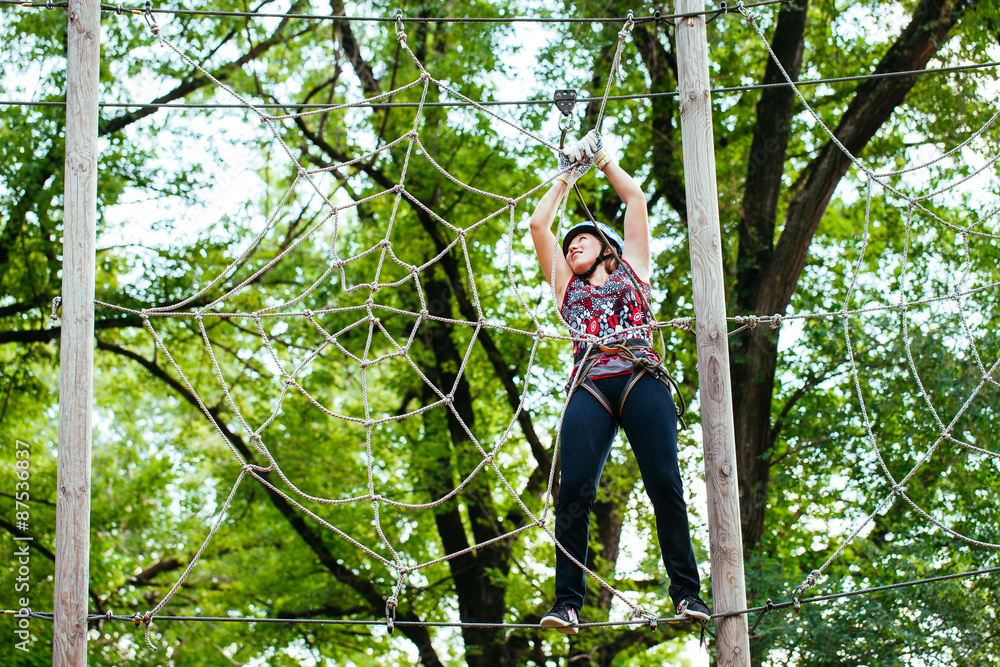 Adventure climbing high wire park - woman on course in mountain Adventure climbing high wire park - woman on course in mountain