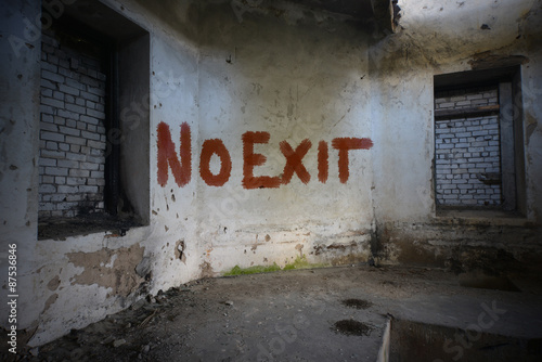text no exit on the dirty old wall in an abandoned ruined house photo