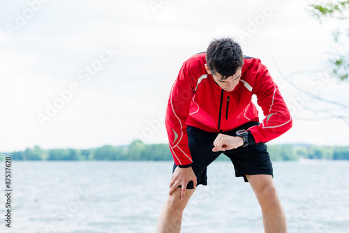 Woman and man at break from running in front of lake