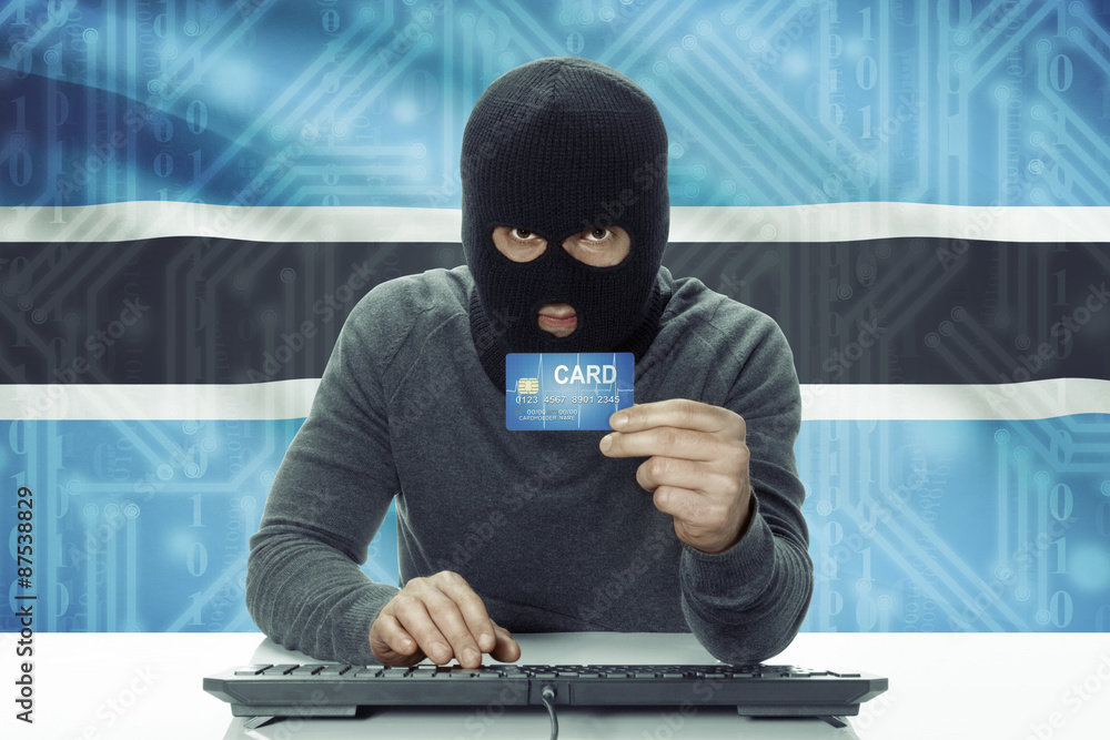 Dark-skinned hacker with flag on background holding credit card - Botswana Dark-skinned hacker with flag on background holding credit card - Botswana
