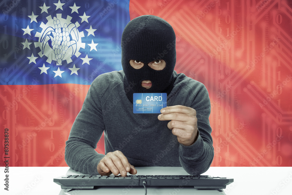 Dark-skinned hacker with flag on background holding credit card - Burma Dark-skinned hacker with flag on background holding credit card - Burma