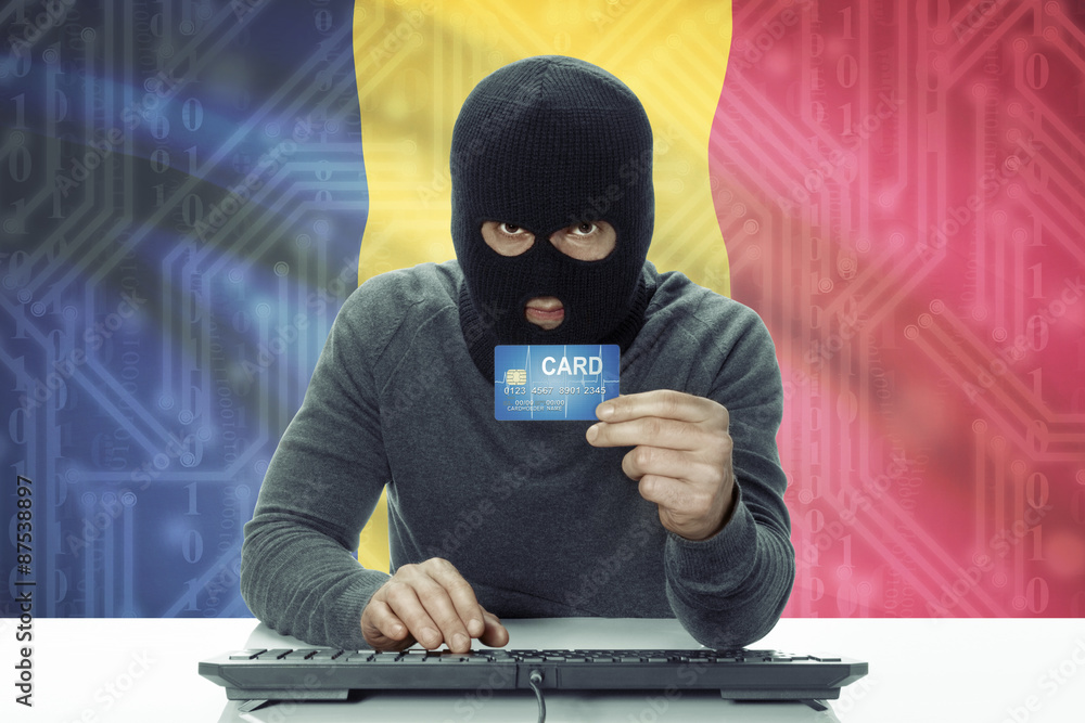 Dark-skinned hacker with flag on background holding credit card - Chad Dark-skinned hacker with flag on background holding credit card - Chad