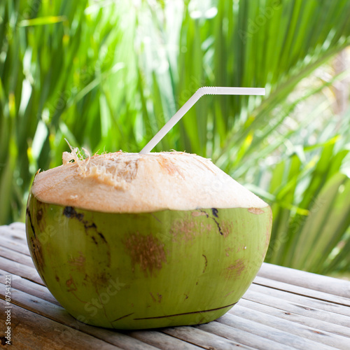Fresh green coconut on palm tree background 