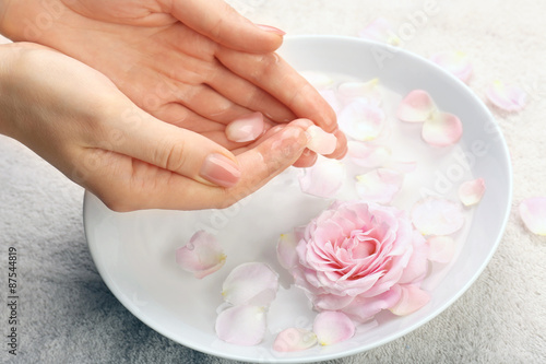 Female hands with bowl of aroma spa water on table  closeup