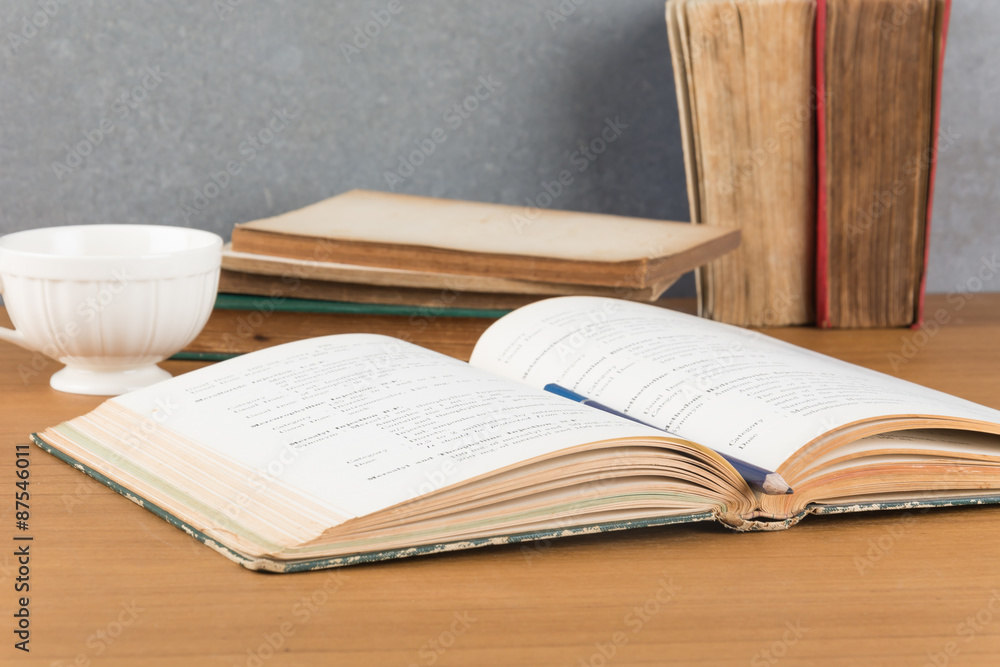 Naklejka premium old book with pencil and coffee