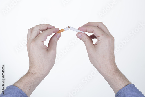 Manos destruyendo un cigarrillo en fondo blanco